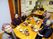 家庭的なサイズの食卓を囲み笑みを浮かべる入居者たち。おいしそうな食事が並んでいる。