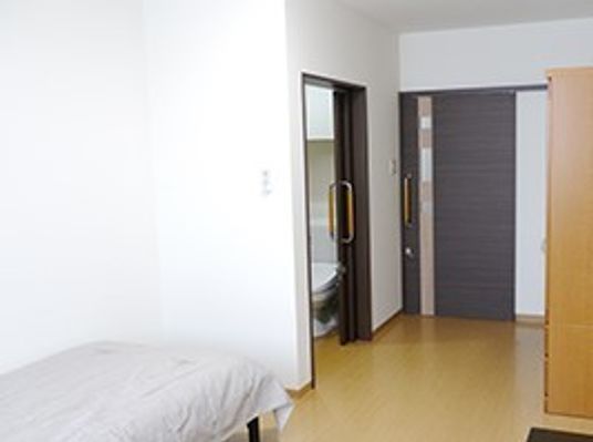 フローリングの居室にはベッドやトイレ、家具が付き、すっきりとしている。