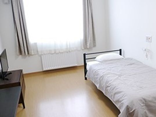 ベッドやテレビ、テーブルを設置した個室には、大きな窓がつきカーテンもある。