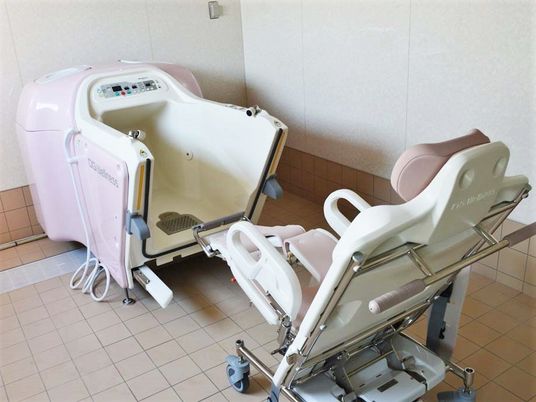 椅子に座った姿勢で入浴できるタイプの介護浴槽の様子。施設にある特殊な形の浴槽