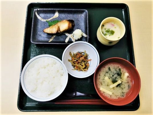 お盆の上にきれいに並べられたメニュー例。ごはんとおかずが数種類並べられている様子