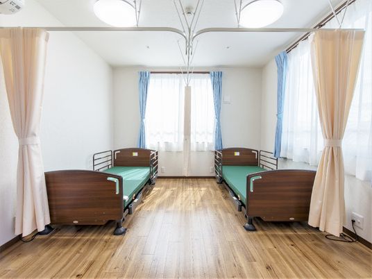 フローリングの居室には介護用ベッドが二つ並び、大きな窓が二つ付いている。