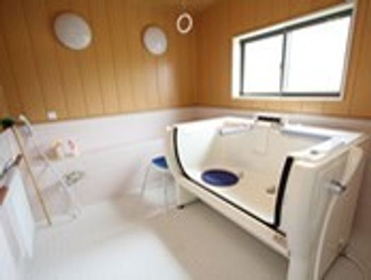 介護度の高い方のための入浴設備。木目調の壁がおしゃれ。
