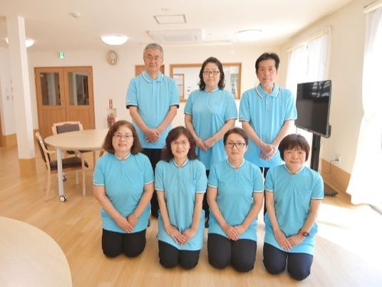 青色の制服を着た有料老人ホーム金色のののスタッフの集合写真