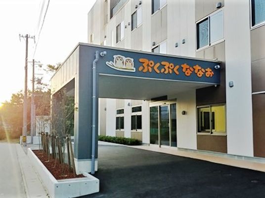 「ぷくぷくななお」という看板が掲げられている施設入りぶちの雨除け用のひさしと外観