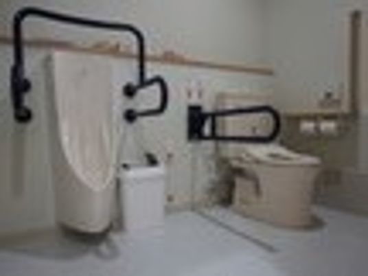 手すり付きのトイレを写した写真。高齢者向けの広めのトイレ