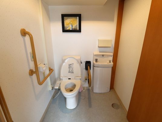 部屋は和風だがトイレは洋式。バリアフリーの床に加え、便器の両側に手すりを取り付けて安全性を高めている。