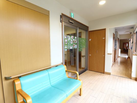 ガラス扉の内側から廊下へと至る手前に、ベンチが設置されている。緑の革張りの二人掛けで、一休みに最適。