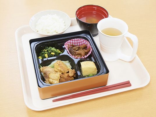 トレイにのったおかずとご飯、お味噌汁とお茶