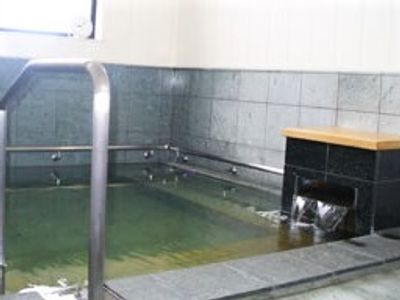 大きな浴槽が設置された浴室には手すりなども設置され、お湯がたっぷり入っている。