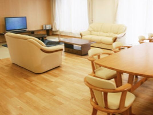 テレビが置かれたリビングにはソファの応接セットがあり、手前にはダイニングテーブルセットが置かれている。