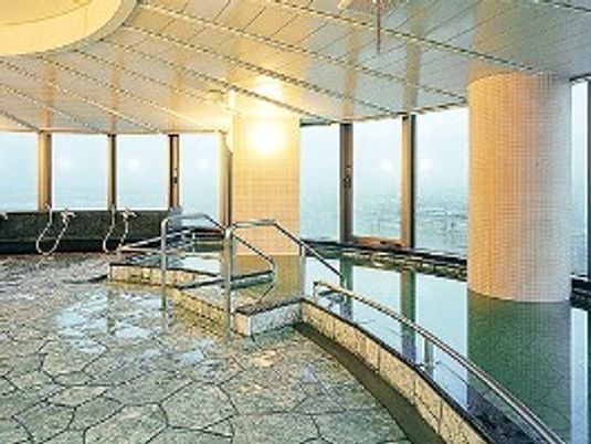 広々とした浴室は一面ガラス張りで大きな浴槽の出入り口には手すり付きの階段が設置されている。