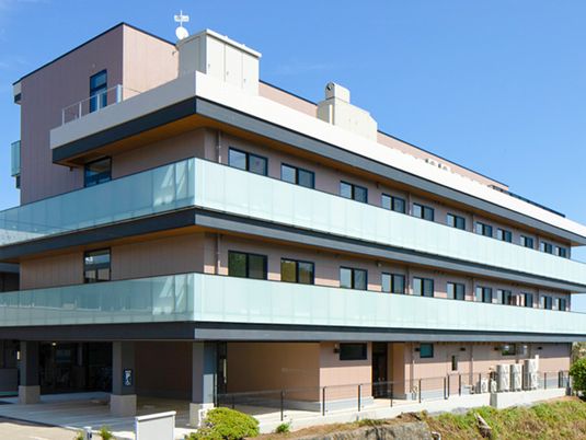 やわらかい色合いの建物の外観写真。住宅型ホームの外観を写したもの