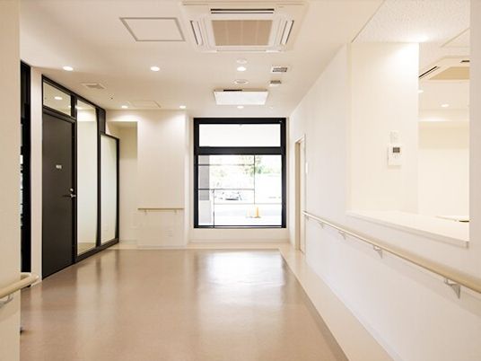 施設内の共有スペースを写した写真。廊下と左側に個室の入り口が見えている様子