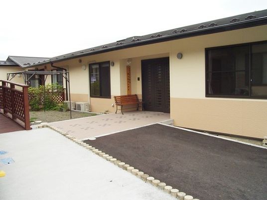 平屋建ての建物の前には段差のない通路が付き、ベンチも置かれている。