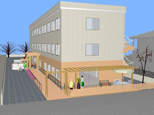 3階建ての建物は車が止まっている正面玄関だけでなく側面にも出入り口があり、ベンチも置かれている。