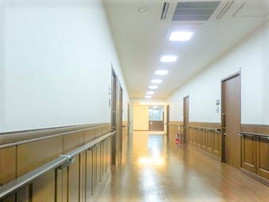 幅の広い廊下は木材をふんだんに私有しており、両側に居室のドアと手すりが設置されている。