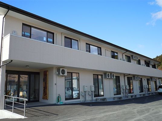 横に長い集合住宅風の建物の外観。フレンズハウス城慈の外観写真
