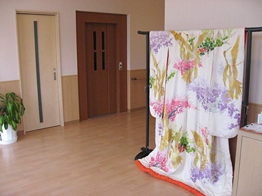はなやかな着物の打掛が飾られている施設内の廊下の様子。エレベーター付近の写真