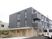 3階建ての建物はコンクリート製でどっしりとした頑丈な建物。2階と3階はグレー1階はベージュ。