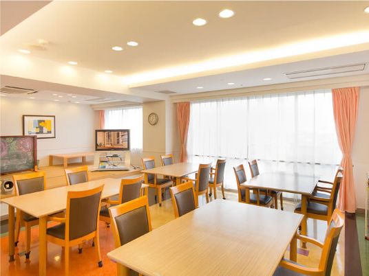 施設内のリビングスペースの写真。大きめの机と椅子が並べられている様子