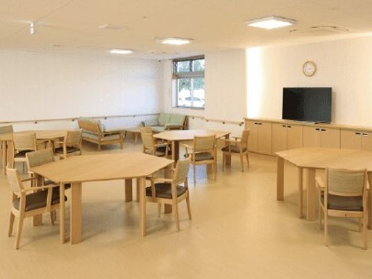 六角形のテーブル、いすが複数並べられている施設内のリビングスペースの様子