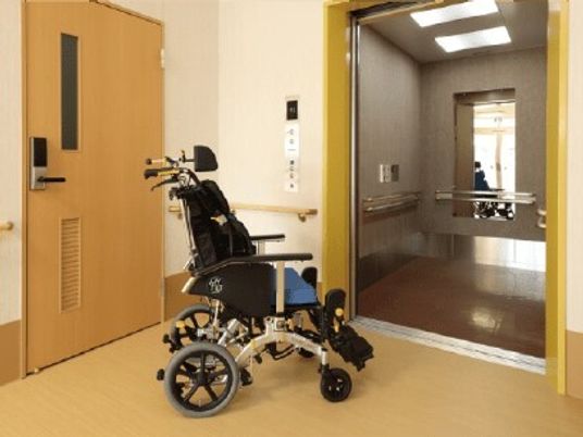 エレベーターと手前に置いてある車いすを写したもの。施設の様子