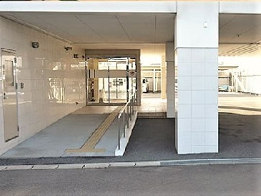 車いす用のスロープがついている施設の入り口付近。利用者用の出入り口の様子