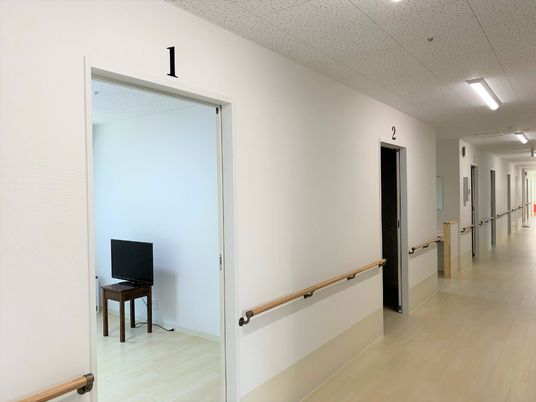 手すり付きの施設の廊下。オールバリアフリーの廊下の様子が映っている