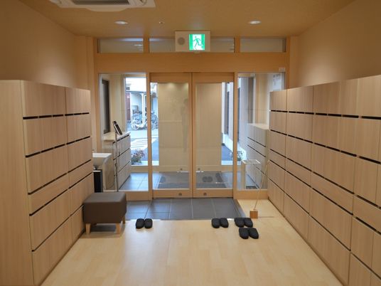 沢山の靴箱が置かれているエントランスにはいすもあり、スリッパも並べられ、風除室も付いている。