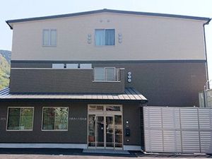 外観はブラウン系で3階建て。周辺は緑が多く、玄関部分には大きな車寄せが付き、ドアは自動、日当たり良好。