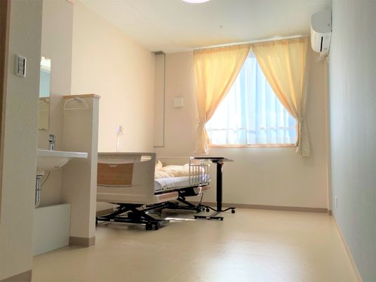 大きな窓が付いた個室には寝具付きのベッドや洗面所、緊急通報装置が付いている。