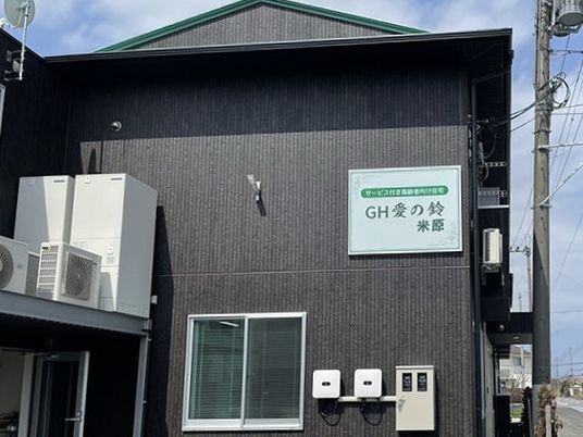 GH愛の鈴米原の看板がある茶色い外壁で三角屋根の2階建てサービス付き高齢者向け住宅