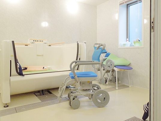 車いすのような装置がついた介護浴槽の様子。座った姿勢のまま入れる浴槽