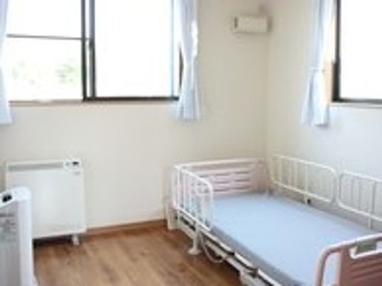 小さな部屋の中にベッドと窓がある様子。エアコンが付いたワンルームの部屋