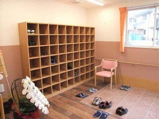 椅子が置かれているエントランス付近。左に靴箱があるオールバリアフリーのエントランス