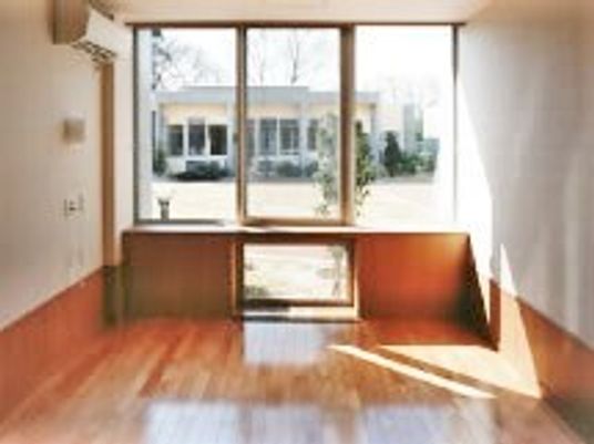 物入れや棚がついている施設内の居室の様子。日当たりの良い一面の窓が印象的なスペース