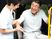 福祉車両から下りようとしている眼鏡姿の高齢男性の手を若いスタッフが支えている様子。