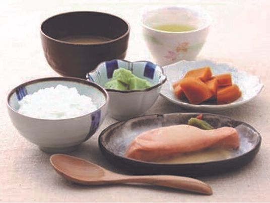 白いご飯に汁物、ブロック状のオレンジやグリーンの副菜、魚のような形のものが盛られている。