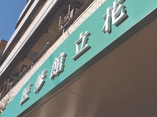 白を基調とした外壁の一部分がグリーンとなっていて、白い立体的な文字でホーム名が書かれている。