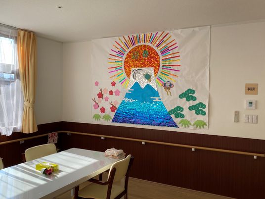 日の出のような模様が描かれている飾りの様子。施設内の共有スペースにある飾りの写真