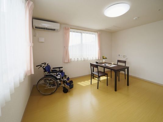 段差のないバリアフリー設計の部屋には車いすやテーブルセット、エアコンがあり、窓も複数付いている。