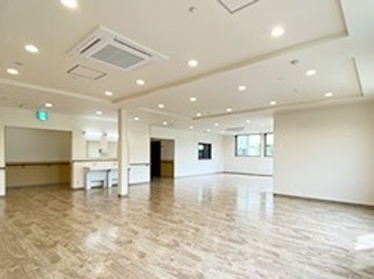 広々とした共有スペースには家具はなく、車いす対応のセメン所があり、窓が複数付いている。
