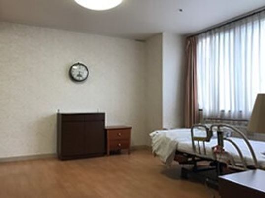 タンスが複数置かれたフローリングの部屋。寝具付きのベッドや時計もあり、明るい雰囲気。