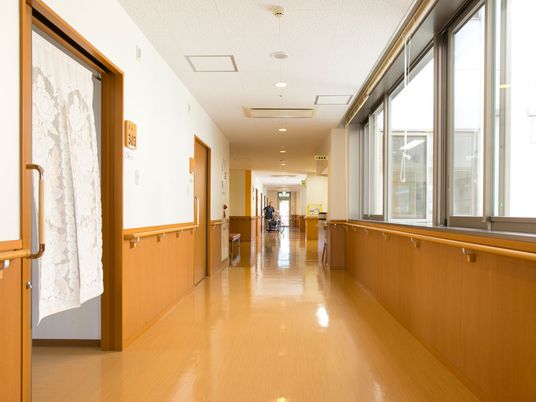 まっすぐな廊下の両サイドに手すりが付き、左側の部屋には暖簾が設置され、通路には何も置かれていない。