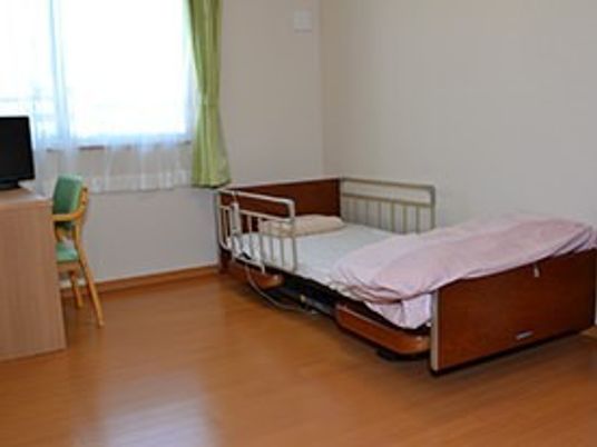 ベッドやテレビ、机、いすなどが並べられている施設の居室の様子