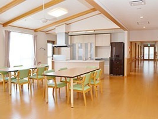 広めの空間にテーブルと椅子が並べられている様子。梁が見えるデザインの空間