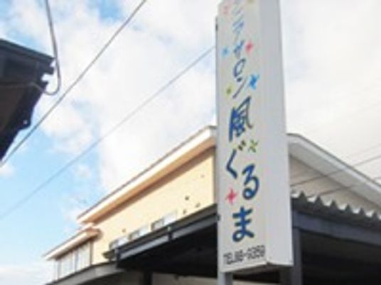 シニアサロンニュー風ぐるまの看板。奥のほうに建物が見えている写真