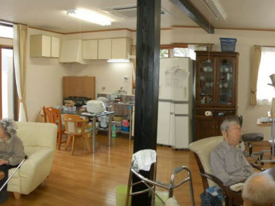 ダイニングテーブルやソファ、テーブルセットが置かれている共有スペースには複数名の入居者がいる。