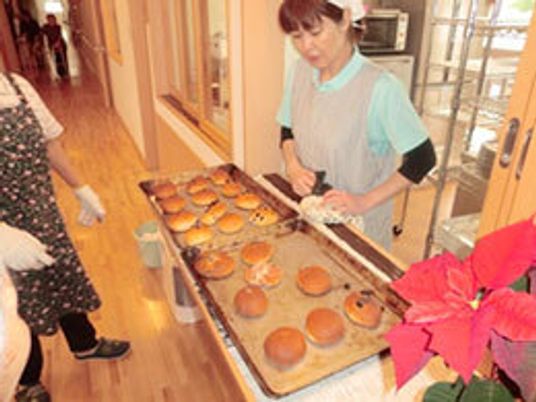 焼き立てパンを販売しているスタッフの様子。トレーにのったパンが置いてある